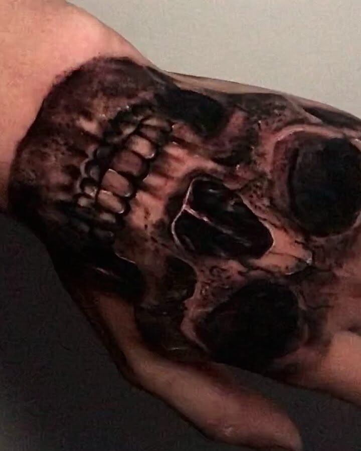 Tatuaje de calavera realista en el dorso de la mano